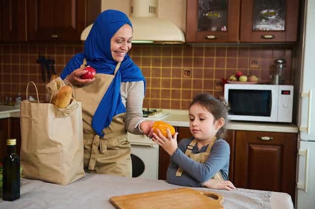 Muslim mother and daughter in the kitchen of their home