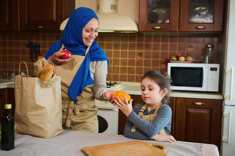 Muslim mother and daughter in the kitchen of their home