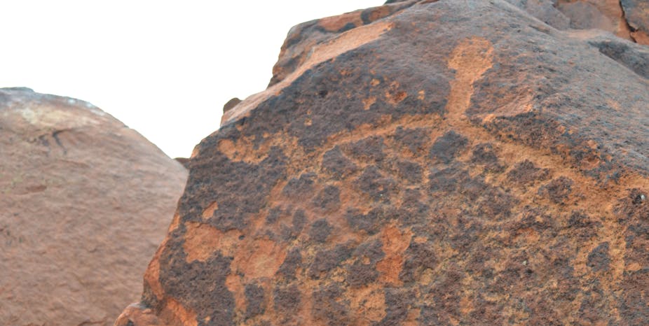 A close-up of red rock art, it looks a bit like a turtle.