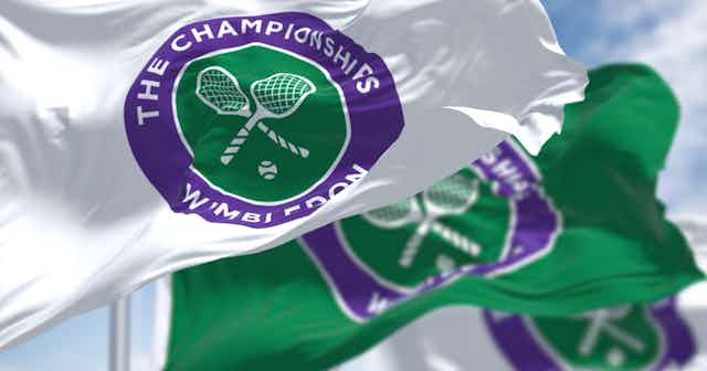 three flags with the The Championships Wimbledon logo waving in the wind