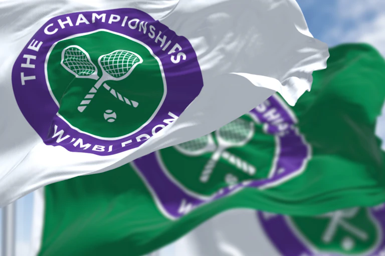 three flags with the The Championships Wimbledon logo waving in the wind