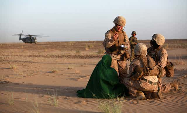 Female soldiers talking to a local woman  in Afghanistan