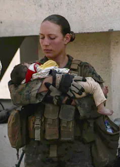Female soldier holding a young child