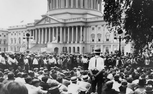 A crowd of men in boaters and white shirts in front of Congress.