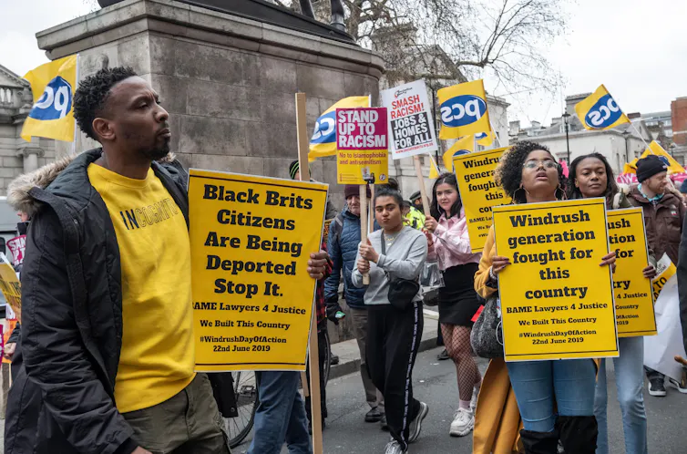 Protestors hold up yellow placards on a rally.