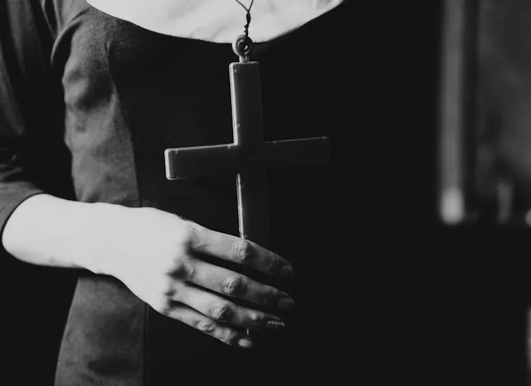 Close up image of a nun holding a crucifix
