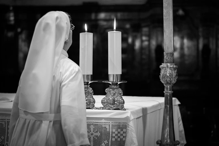 A nun blows out church candels.