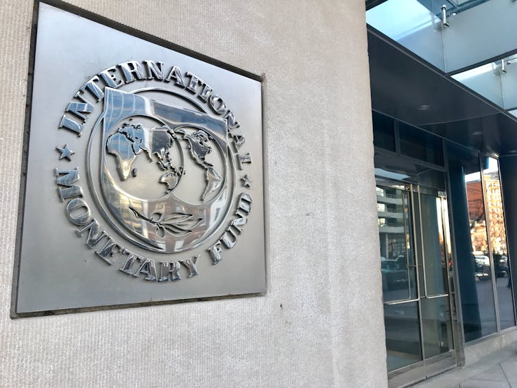 a plaque on a building showing the IMF logo and the text INTERNATIONAL MONETARY FUND