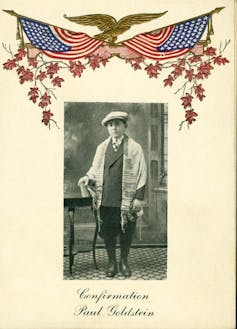 A yellowed invitation with a photo of a young boy and brightly colored American flags on top.
