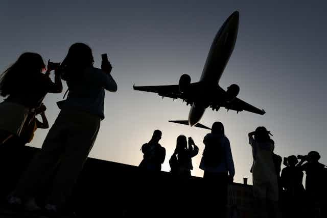silhouette of plane and people photographing it