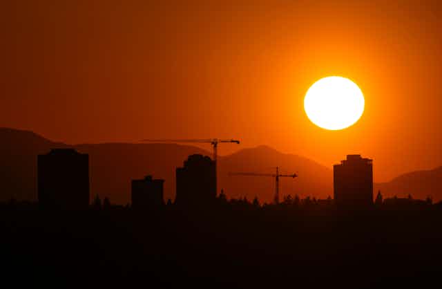 Sun sets over a city after a day of extreme heat