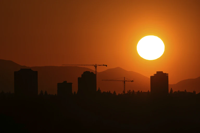 Sun sets over a city after a day of extreme heat