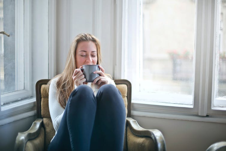 woman sits with cup of tea