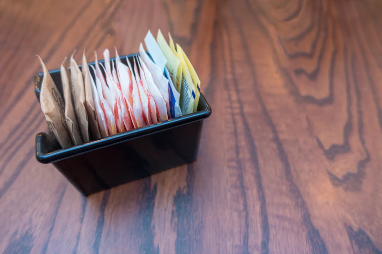 packets of sugar and sweeteners on table top