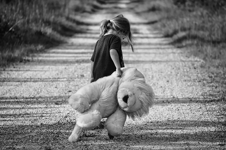 petite flle avec un ours en peluche en noir et blanc
