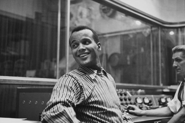 Harry Belafonte seated in a recording studio in the late 1950s.