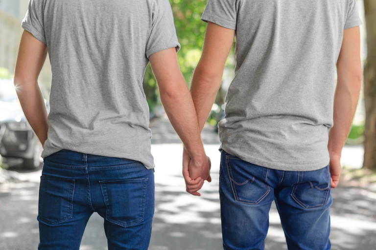 Couple d'hommes vus de dos se tenant par la main