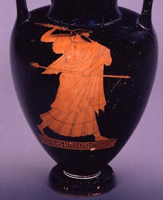 Ánfora con Zeus dibujado. Zeus camina hacia la derecha lanzando un rayo; en la izquierda sostiene el cetro sobre el cuerpo; lleva barba y el pelo largo suelto sobre el brazo derecho, con un mechón cayendo sobre el pecho.