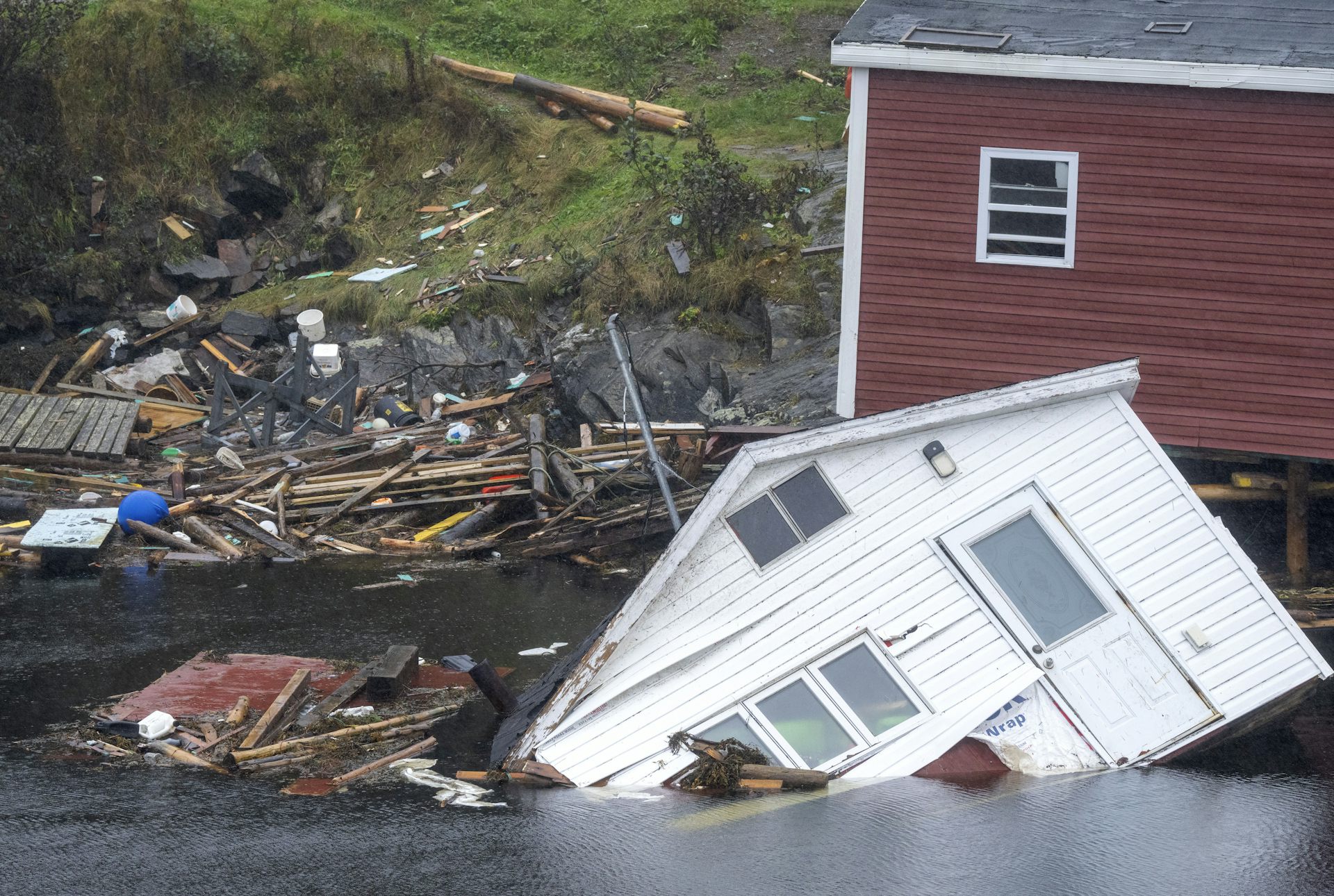 Destroyed buildings in the water in a seaside village.