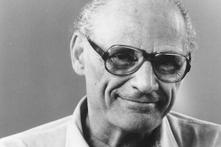 Arthur Miller wearing glasses and a collard shirt in a black and white photograph.
