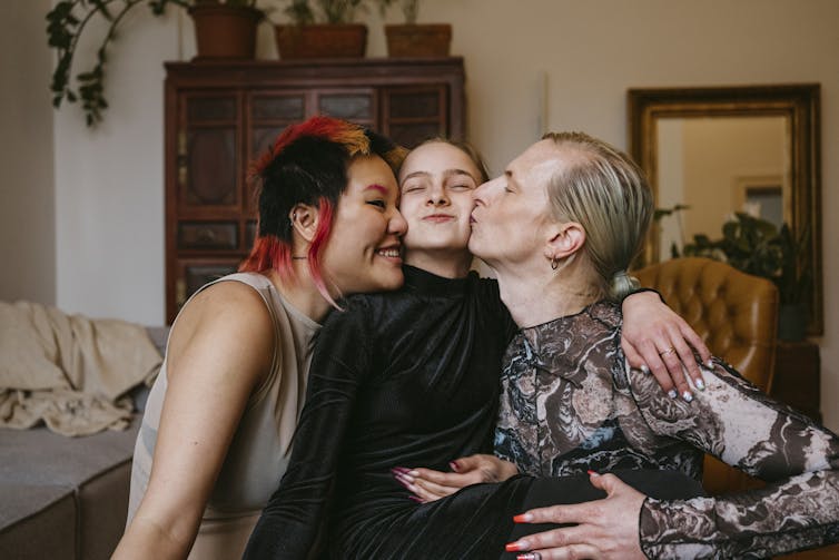 Parents kissing child on either cheek