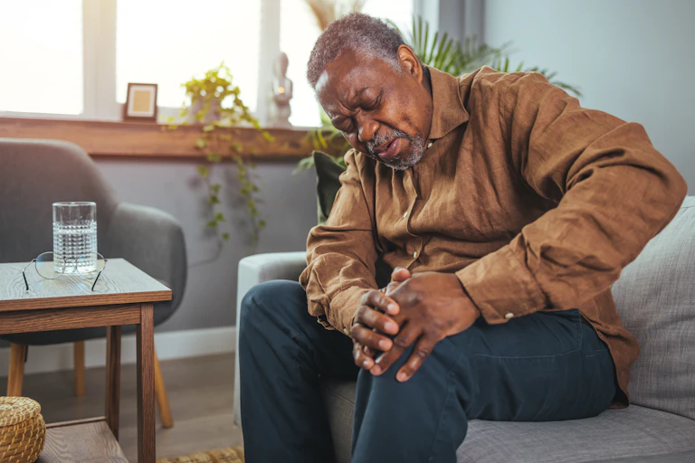 Older man holding his arthritic knee