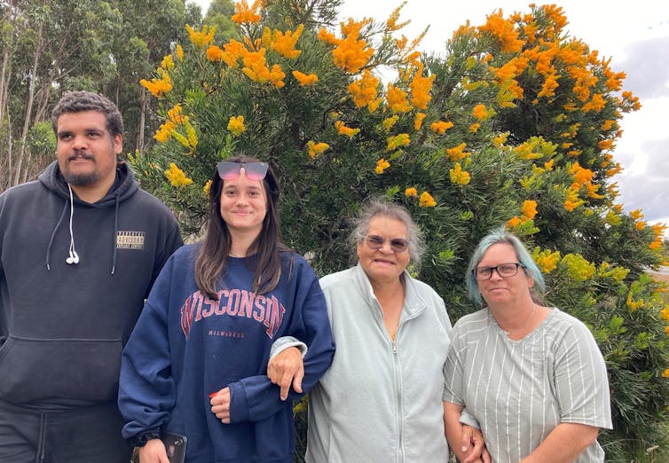 A family photograph showing (left to right) Harrison Rodd-Knapp, Jessikah Woods, Lynette Knapp and Shandell Cummings, with flowering mungee near Waychinicup, on Merningar Country