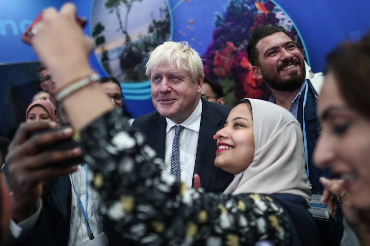 Boris Johnson tirando selfies com pessoas.