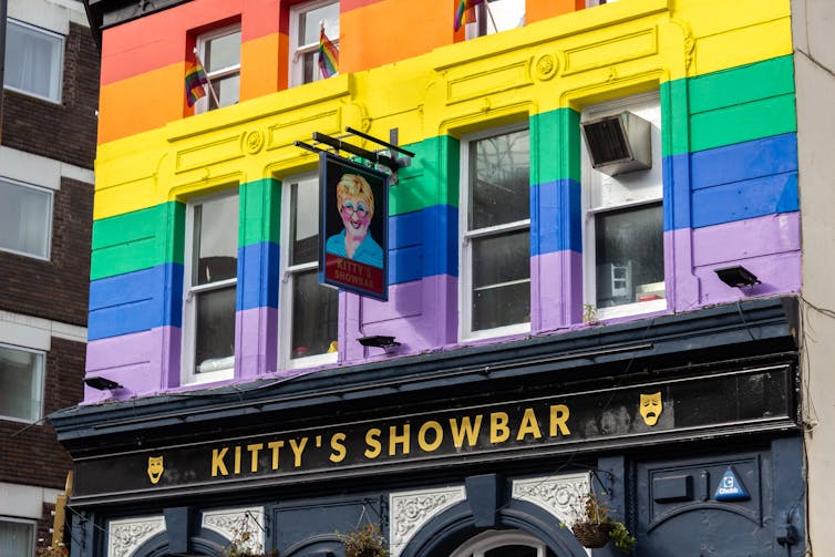 Front facade of Kitty's Showbar in Liverpool, a corner pub with the building painted in rainbow stripes