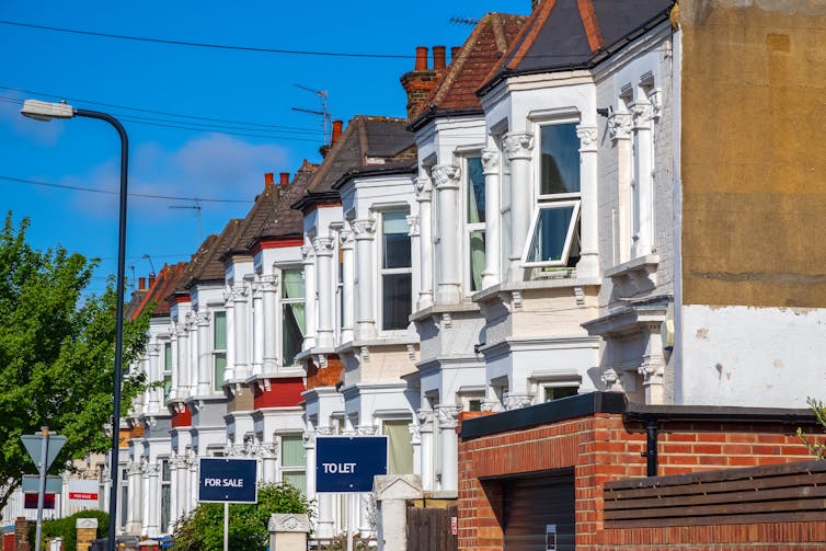 A row of Victorian terraced houses with some To Let signs in front.