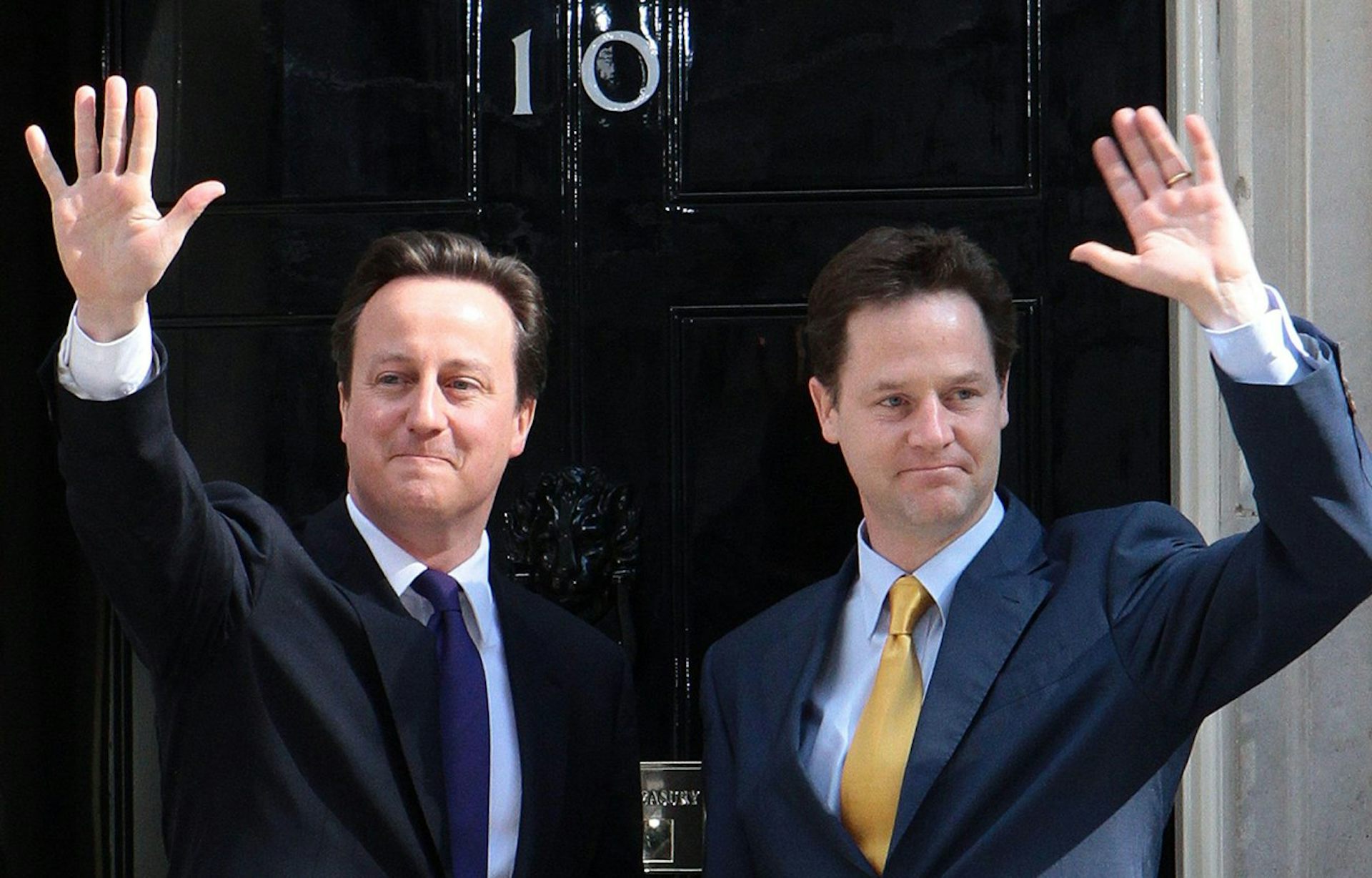 David Cameron and Nick Clegg waving outside 10 Downing Street.