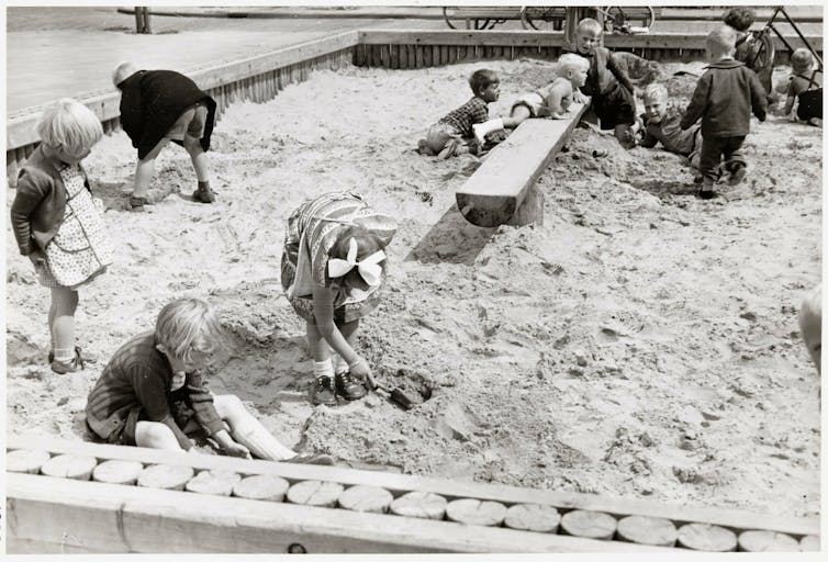 An archival photograph of children in a sandpit.