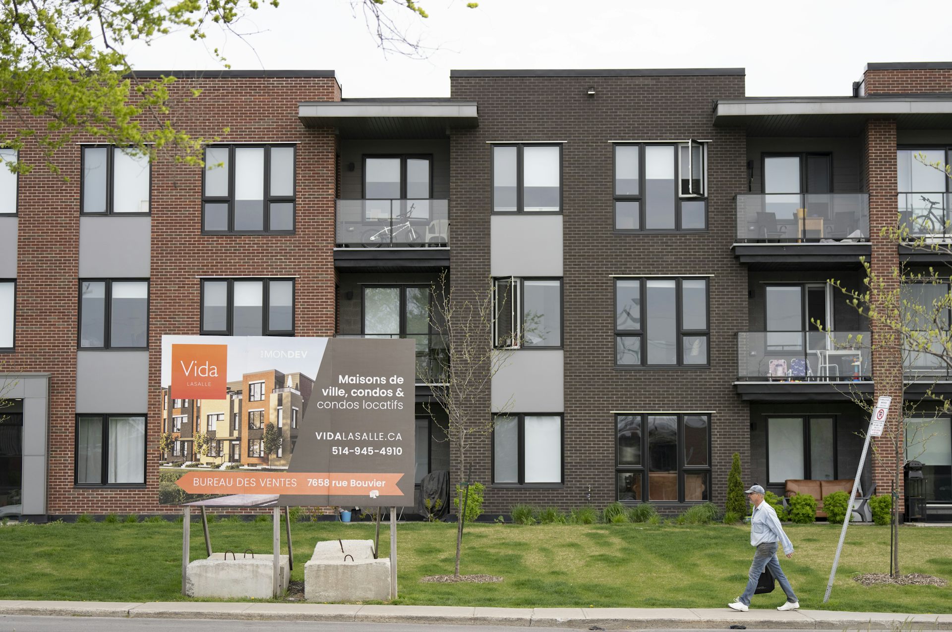 An advertisement for a condominium is seen outside a low-rise building