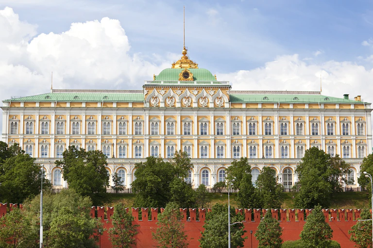 The facade of the Kremlin palace, with trees in front of it.
