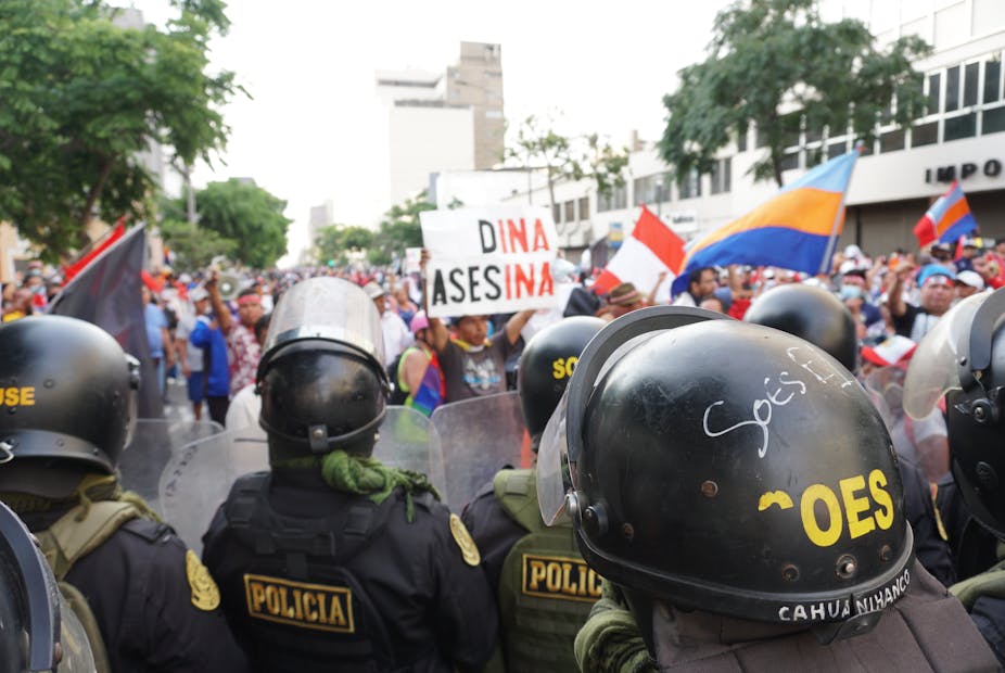 Des civils péruviens encadrés par la police protestent contre leur nouvelle présidente Dina Boluarte.