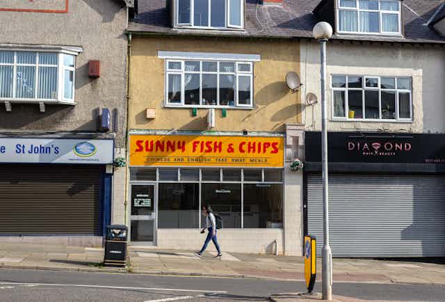 A takeaway shop with a yellow sign that says Sunny Fish and Chips.