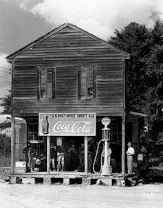 Black and white image of a small country store with a 'Drink Coca-Cola' sign over the door.