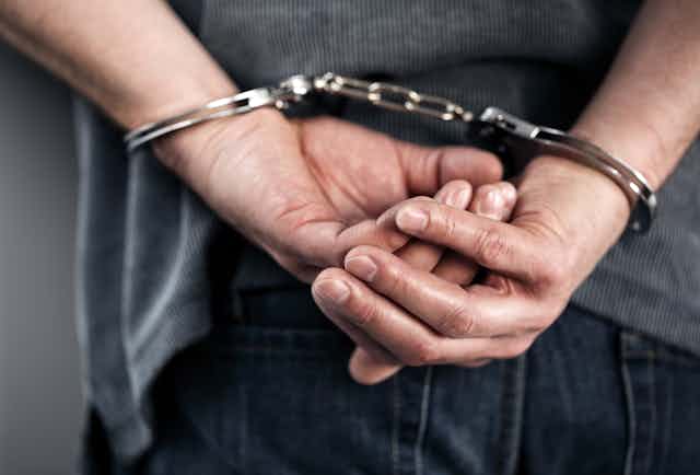 A man's hands in handcuffs, behind his back