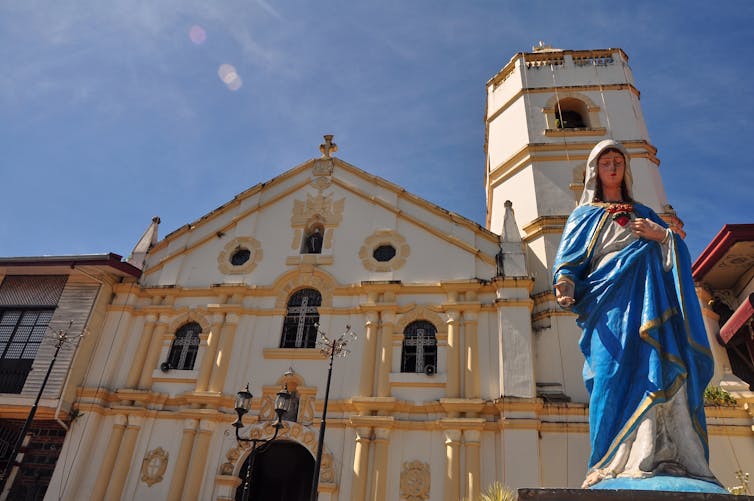 A statue of the Virgin Mary draped in a blue robe.