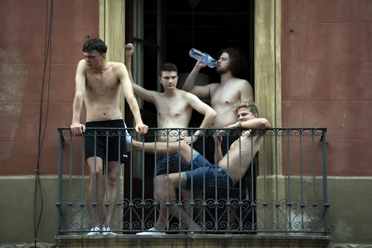 four young men cool off on balcony