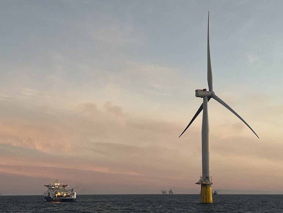 A floating wind turbine at sunset.