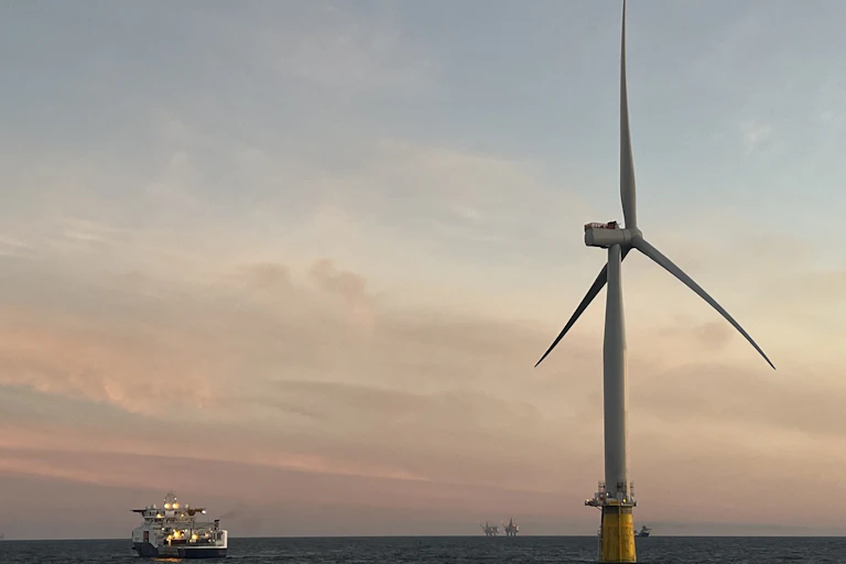 A floating wind turbine at sunset.