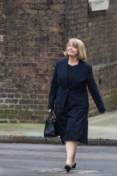 Harriett Baldwin crossing a road