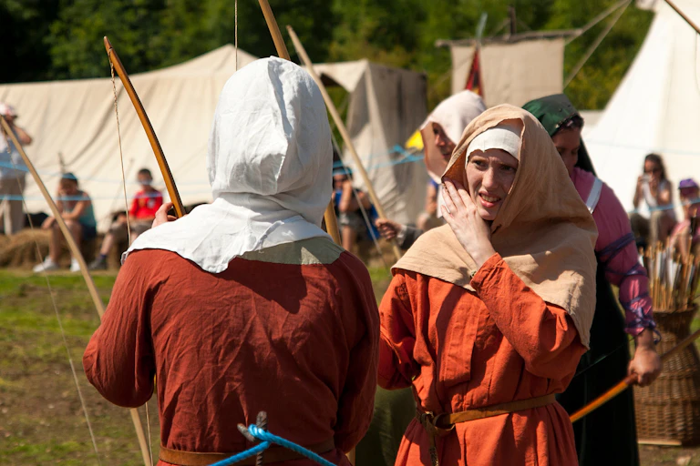 People in historic costume holding bows