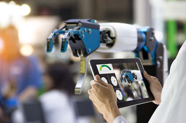 Robot arm being controlled using a tablet computer.