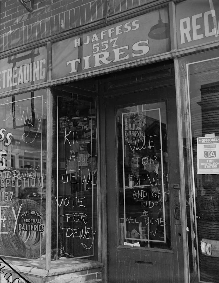 Writing is seen on the glass doors of a tire merchant's storefront.