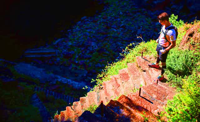 Un ultratrailer se tient debout devant un escalier improbable dans la nature