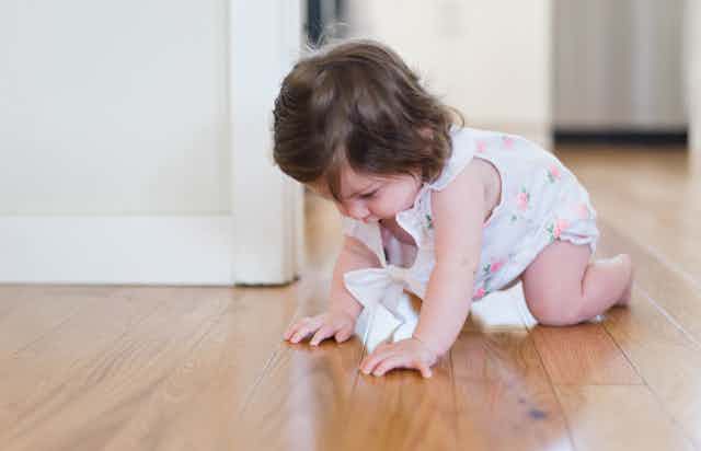 infant girl crawling on floor