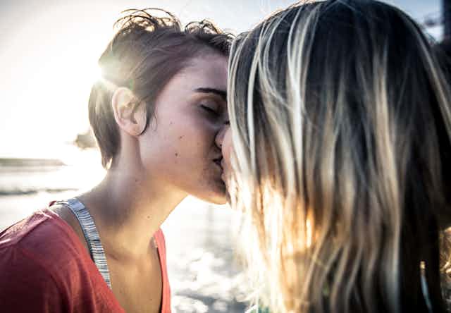 Two young people kissing.