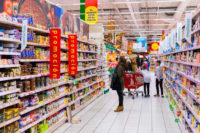Personas comprando en el pasillo de un supermercado.